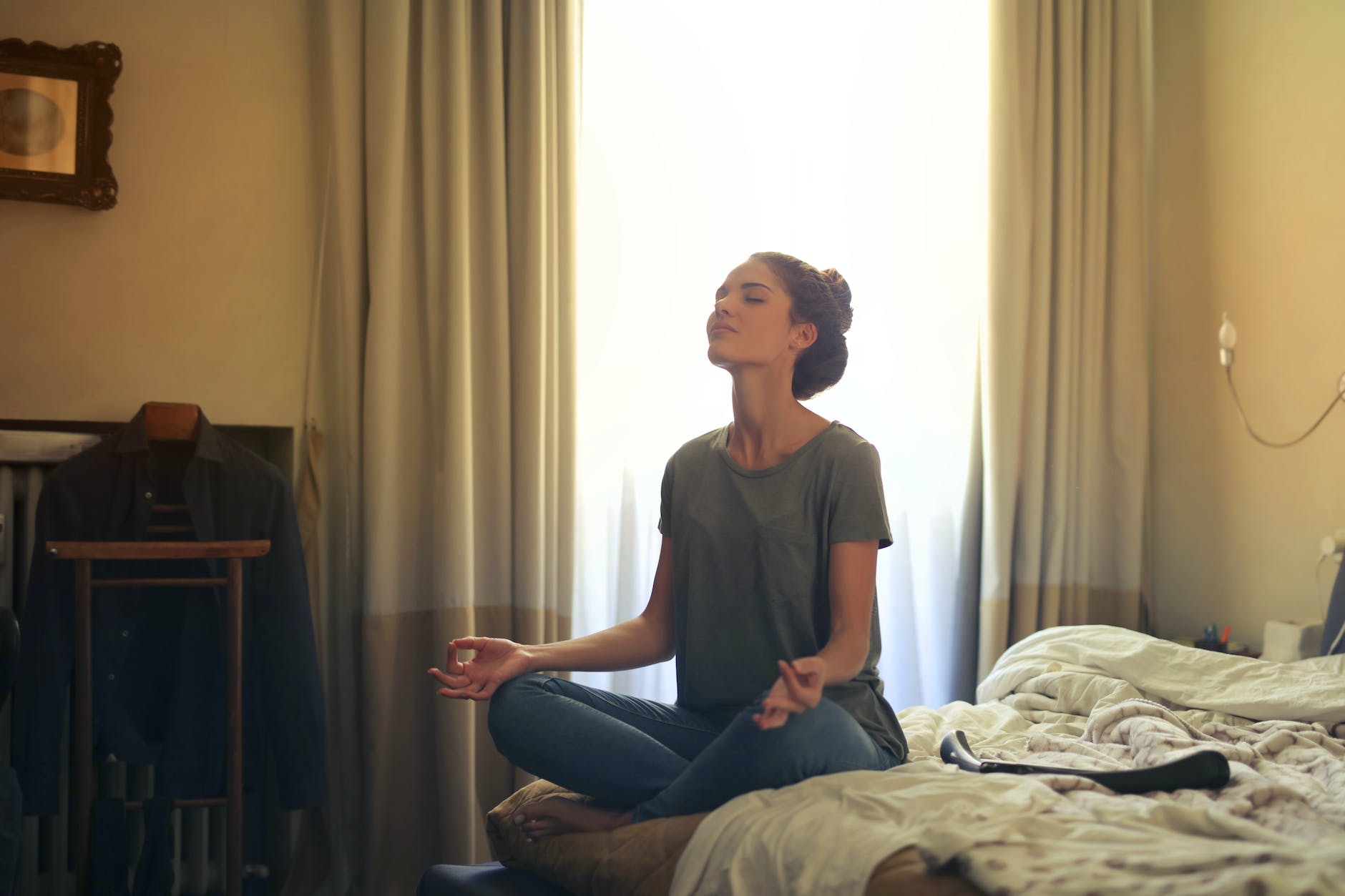 woman meditating in her bedroom quiet and peaceful